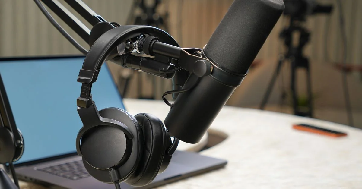 Gros plan sur l'installation d'un studio de podcast avec un microphone et des écouteurs.