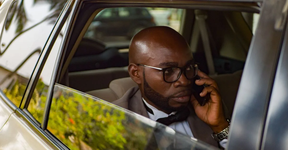 Un cadre africain parlant au téléphone à l'intérieur d'une voiture.