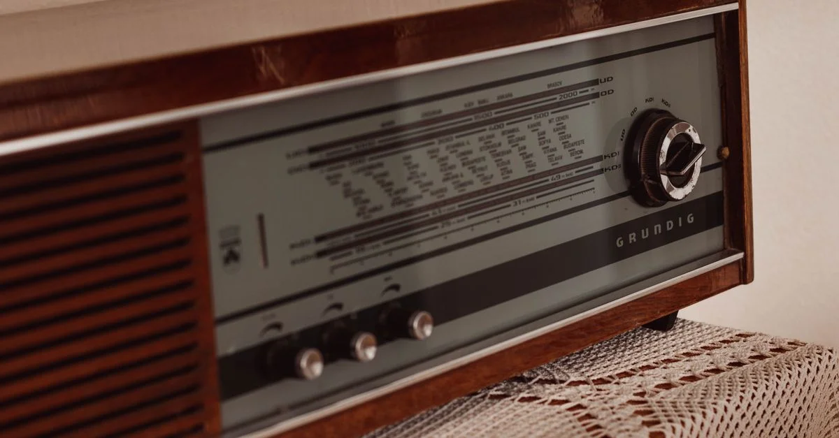 Radio en bois rétro sur une nappe en dentelle, capturant une ambiance nostalgique et classique.